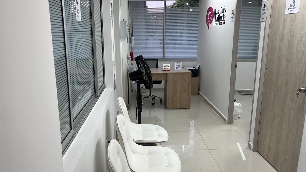 Sala de espera de Clínica Psicológica Renacer con el logotipo de Luz Inés Lalinde en la pared